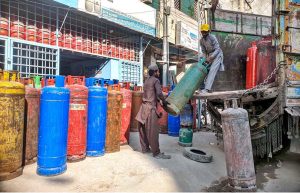 Labourers are busy unloading gas cylinder from delivery truck at shop in Ghouri Town