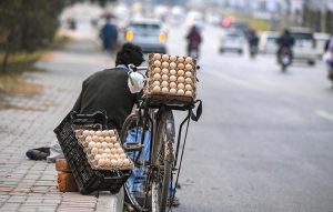 A street vendor waits for customers as he sells eggs along the footpath on Chak Shahzad Road in the federal capital.