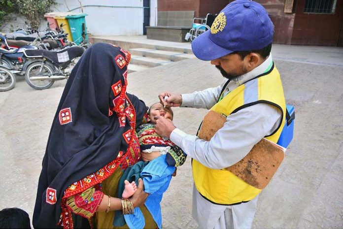 Health worker administering polio drops to a child during Anti-Polio Vaccination Campaign at Shah Bhitai Hospital