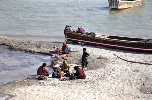 Women are busy washing the clothes at the bank of Indus River.
