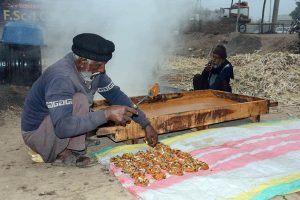 Farmers prepare the traditional sweet, jaggery (gur) during the sugarcane processing season at their workplace.