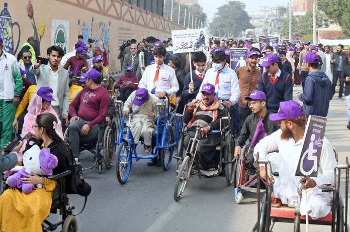 Special persons participate in an awareness walk at Kalma Chowk to mark the International Day of Persons with Disabilities
