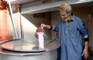 A shopkeeper prepares pink hot tea to serve customers to keep themselves warm as demand rises with the onset of winter at Lakshmi Chowk.