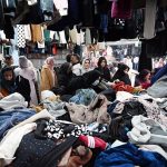 People busy selecting and purchasing second hand clothes from vendor at H-9 weekly Bazaar in the Federal Capital