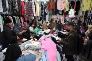 People busy selecting and purchasing second hand clothes from vendor at H-9 weekly Bazaar in the Federal Capital