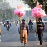 Street hawkers carry cotton candy along the roadside to draw customers’ attention.