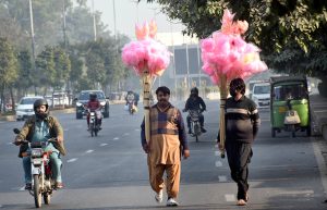 Street hawkers carry cotton candy along the roadside to draw customers’ attention.