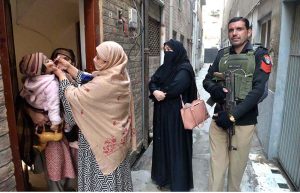 Polio Health workers administering polio drops to a child during a door-to-door polio vaccination campaign in the Provincial Capital.