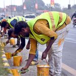 CBD workers paint a safety fence to enhance road safety measures in the area