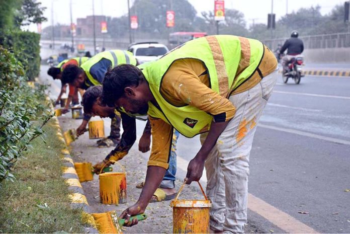 CBD workers paint a safety fence to enhance road safety measures in the area