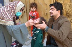 Polio Health workers administering polio drops to a child during a door-to-door polio vaccination campaign in the Provincial Capital.