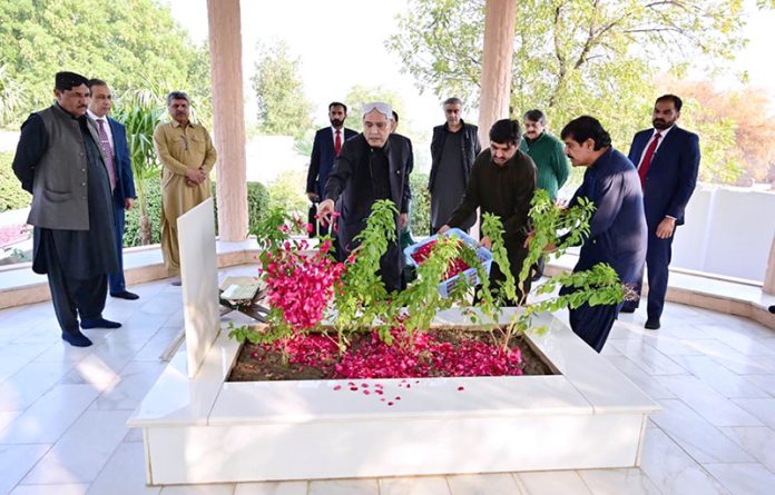 President Asif Ali Zardari lays flowers on the grave of his father, Sardar Hakim Ali Zardari, at Baloo Ja Quba