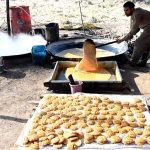 Farmers busy boiling sugarcane juice to prepare traditional sweet products, Jaggery (Gurr) and brown sugar (Shakkar), at their farm on the outskirts of the provincial capital