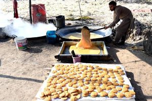 Farmers busy boiling sugarcane juice to prepare traditional sweet products, Jaggery (Gurr) and brown sugar (Shakkar), at their farm on the outskirts of the provincial capital