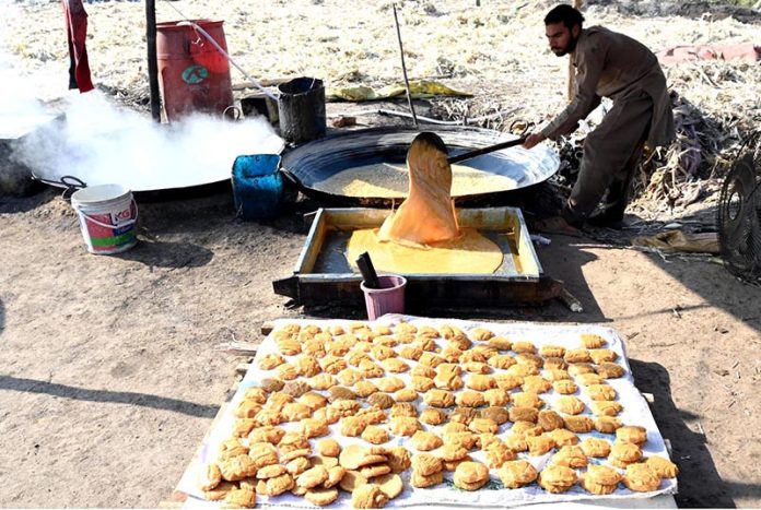 Farmers busy boiling sugarcane juice to prepare traditional sweet products, Jaggery (Gurr) and brown sugar (Shakkar), at their farm on the outskirts of the provincial capital