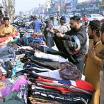 People purchasing second-hand clothes from roadside vendors to keep them warm and battle the winter chill