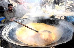 Farmers busy boiling sugarcane juice to prepare traditional sweet products, Jaggery (Gurr) and brown sugar (Shakkar), at their farm on the outskirts of the provincial capital