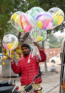 A street vendor displaying the colorful balloons to attract the customers at Sachal Colony Road.