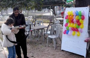 A girl concentrating on shooting balloons with a gun at Gulshan-e-Iqbal Park in the Provincial Capital.