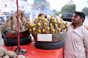 A street vendor displaying Sweet potatoes to attract the customers at Sachal Colony Road.