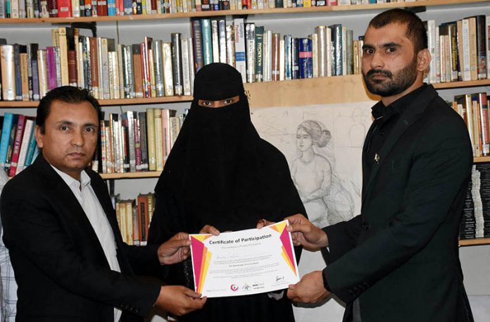 Muhammad Shoaib Ayoub Batalvi, chief guest, with Tariq Saeed, founder of The Knowledge of Art Academy, distributing certificates during the ceremony