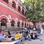 A large number of patient relatives wait on the footpath outside a Civil Hospital ward due to limited space for attendants inside