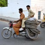 Motorcyclists transport damaged and recyclable tyres and tubes collected from various points to earn their livelihood