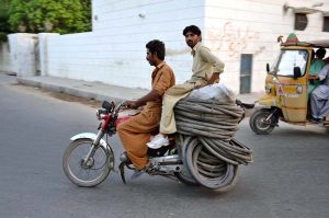 Motorcyclists transport damaged and recyclable tyres and tubes collected from various points to earn their livelihood