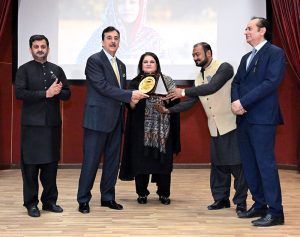 Chairperson Benazir Income Support Programme (BISP), Senator Rubina Khalid, presents a shield to Chairman Senate Syed Yousaf Raza Gillani, in the presence of Secretary BISP Amir Ahmad Ali at BISP Headquarters