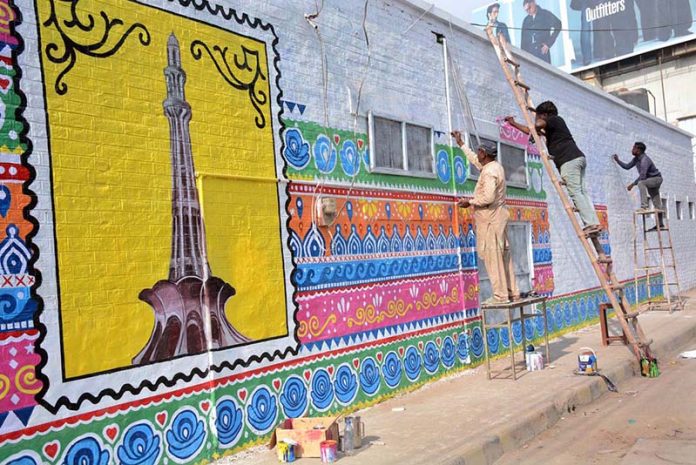 Artists create colorful murals on the walls of Government MC Girls High School Jhal Khanwana