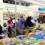 People browse and shop at book stalls on the third day of the Karachi World Book Fair.