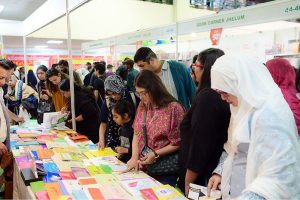 People browse and shop at book stalls on the third day of the Karachi World Book Fair.