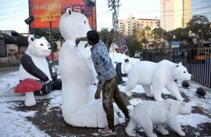 A worker paints a statue of Panda by the PHA near the Liberty Roundabout.