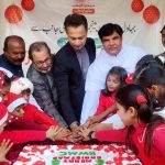 Deputy Commissioner Syed Hassan Raza cuts a Christmas cake with members of the Christian community and children at Islami Colony. APP/HBR/FHA