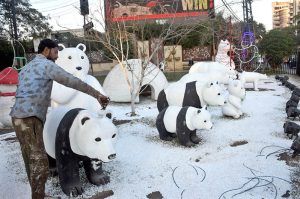 A worker paints a statue of Panda by the PHA near the Liberty Roundabout.