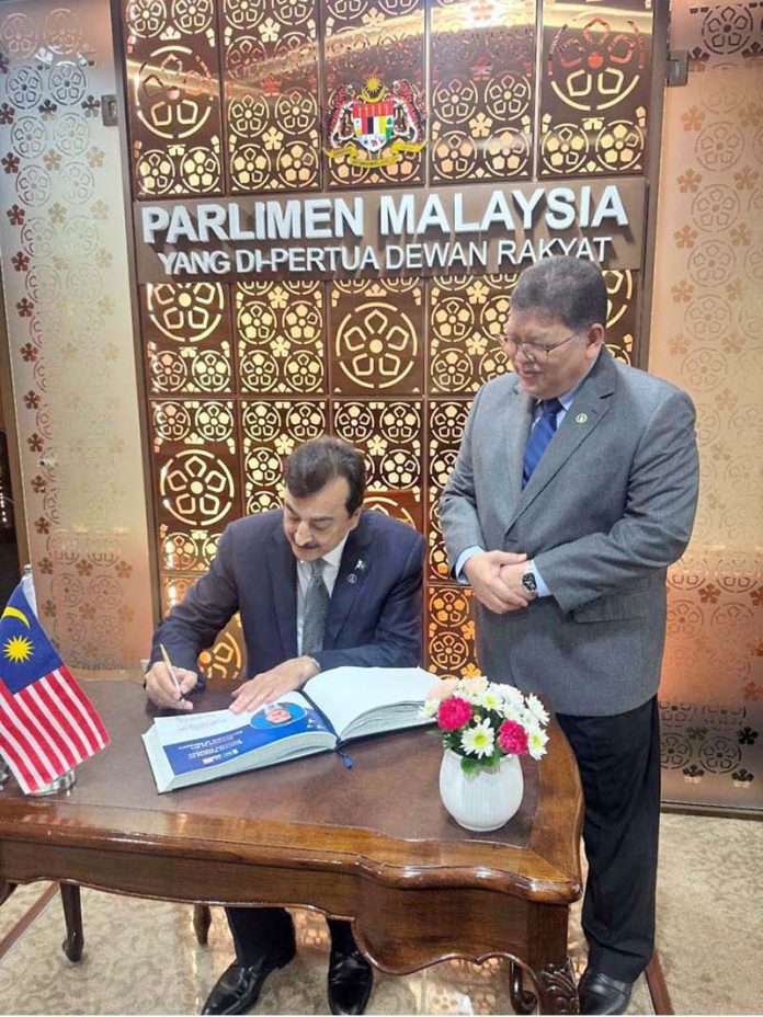 Chairman Senate of Pakistan, Syed Yousaf Raza Gilani recording his comments on visitor’s book placed at Parliament of Malaysia