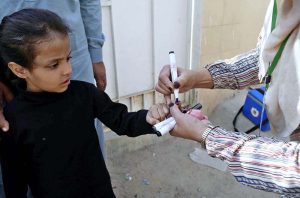 A lady health worker administers polio drops to a child during the “Polio-Free Pakistan” campaign as part of the ongoing immunization drive