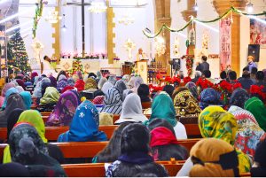 Christian community members performing religious rituals on Christmas Day at St. Thomas Church.