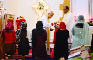 Christian community members performing religious rituals on Christmas Day at St. Thomas Church.