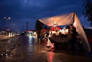 A vendor selling peanuts along Srinagar highway in Bhara kahu during the first spell of rain in capital.