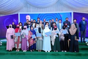 Prime Minister Muhammad Shehbaz in a group photo with the recipients of laptops. APP/ABB