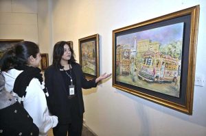 Visitors taking keen interest in an artwork by an artist BARKAT on special needs, who graduated as Fine Artist from NCA Lahore, on display at the NCA Islamabad Campus during an exhibition on the eve of International Day of persons with Disabilities