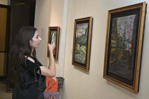Visitors taking keen interest in an artwork by an artist BARKAT on special needs, who graduated as Fine Artist from NCA Lahore, on display at the NCA Islamabad Campus during an exhibition on the eve of International Day of persons with Disabilities