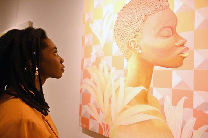 A foreign visitor viewing an artwork on display at International Art Exhibition during World Culture Festival