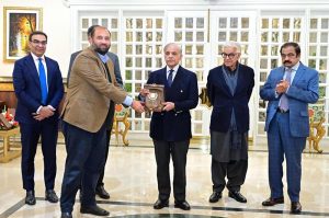 Prime Minister Muhammad Shehbaz Sharif presents shields to the members of government team which led the privatisation of PIA.