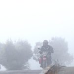 Motorcyclist pass through dense fog in the early morning along the expressway in the Federal Capital.