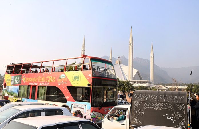 People enjoy a ride on the double-decker bus at Faisal Masjid, part of a service aimed at promoting tourism in the Federal Capital