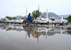 A view of Faisal Masjid’s reflection in the water accumulated on road in front of Faisal Masjid after rain in the twin cities.