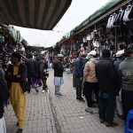 People select and purchase second-hand shoes from vendors at the weekly Sunday Bazaar at H-9 in the Federal Capital