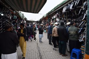 People select and purchase second-hand shoes from vendors at the weekly Sunday Bazaar at H-9 in the Federal Capital